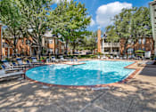 Thumbnail 21 of 25 - A pool surrounded by trees and chairs in a sunny day.