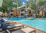 Thumbnail 17 of 25 - A pool surrounded by lounge chairs and trees.