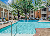 Thumbnail 20 of 25 - A swimming pool in front of a building with a white pergola.