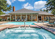 Thumbnail 16 of 25 - A pool in front of a house with a porch.