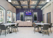Thumbnail 6 of 25 - A modern dining room with a fireplace and a TV above it.