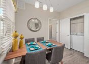 Thumbnail 4 of 23 - a dining room with a table and chairs and a mirror