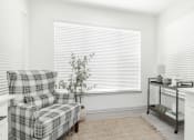 Thumbnail 2 of 35 - a living room with a plaid chair and a window with white blinds