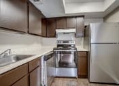 Thumbnail 10 of 26 - a kitchen with stainless steel appliances and wooden cabinets