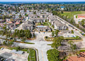 Thumbnail 25 of 28 - A bird's eye view of a residential area with apartment buildings and a parking lot.