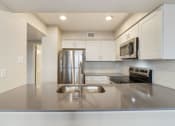 Thumbnail 6 of 28 - a kitchen with white cabinets and stainless steel appliances