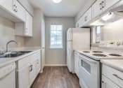 Thumbnail 6 of 16 - an empty kitchen with white appliances and white cabinets
