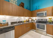 Thumbnail 1 of 25 - a kitchen with stainless steel appliances and wooden cabinets
