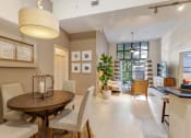 Thumbnail 6 of 25 - a dining room and living room with a table and chairs
