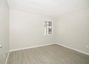 Thumbnail 9 of 28 - a bedroom with hardwood floors and white walls