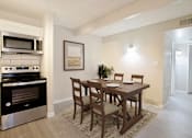 Thumbnail 5 of 28 - A kitchen with a table and chairs and a fridge.
