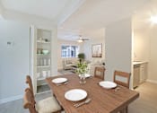 Thumbnail 4 of 28 - A dining room with a wooden table set for two.