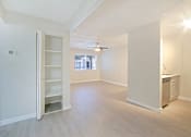Thumbnail 8 of 28 - an empty living room with a kitchen in the background