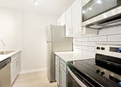 Thumbnail 2 of 28 - a kitchen with white cabinets and stainless steel appliances