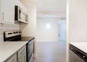 Thumbnail 3 of 28 - a kitchen with white countertops and stainless steel appliances