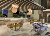 Thumbnail 17 of 17 - a patio with tables and chairs and an outdoor kitchen