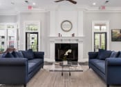 Thumbnail 2 of 17 - a living room with blue couches and a fireplace