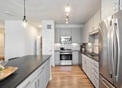 Thumbnail 3 of 33 - A modern kitchen with stainless steel appliances and wooden floors.