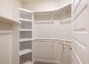 Thumbnail 11 of 33 - A white closet with shelves and hangers.