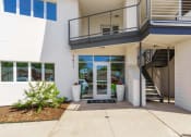 Thumbnail 17 of 29 - the entrance to a white building with a staircase and a glass door