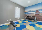 Thumbnail 17 of 20 - a workout room with a gym bench and a wall mural of the beach