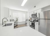 Thumbnail 8 of 35 - a white kitchen with stainless steel appliances and white counter tops