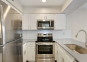 Thumbnail 2 of 28 - a kitchen with white cabinets and stainless steel appliances