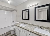 Thumbnail 53 of 54 - A bathroom with a toilet, sink, and mirror.