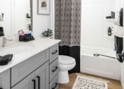 Thumbnail 7 of 30 - a bathroom with white walls and a black and white shower curtain