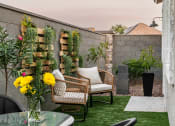 Thumbnail 12 of 30 - a patio with chairs and a table with a vase of flowers on it