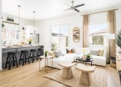 Thumbnail 16 of 30 - a living room and kitchen with white walls and wood floors