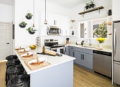 Thumbnail 20 of 30 - a kitchen with white walls and gray cabinets
