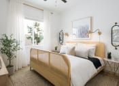 Thumbnail 21 of 30 - a bedroom with white walls and a bed with a wooden headboard