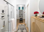 Thumbnail 9 of 30 - a bathroom with a glass shower stall and a black and white rug