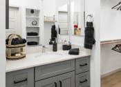 Thumbnail 23 of 30 - a bathroom with gray cabinets and a white countertop