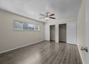 Thumbnail 8 of 11 - an empty living room with a ceiling fan and a closet