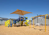 Thumbnail 21 of 21 - A playground with a yellow slide and a yellow umbrella.