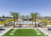 Thumbnail 16 of 21 - A pool surrounded by palm trees and lounge chairs.