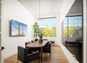 Thumbnail 13 of 21 - A modern dining room with a wooden table and chairs.