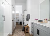 Thumbnail 11 of 20 - A bathroom with a glass shower door and a white sink.
