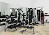 Thumbnail 18 of 20 - A woman is walking in a gym with a variety of exercise equipment.