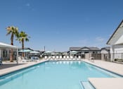 Thumbnail 19 of 20 - A large swimming pool surrounded by lounge chairs and umbrellas.