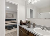 Thumbnail 8 of 22 - A bathroom with a white sink, a mirror, and a large mirror above the sink.