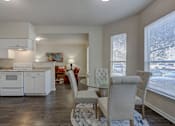 Thumbnail 18 of 18 - A modern kitchen with white cabinets and a dining area with a glass table.