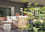 Thumbnail 33 of 37 - A modern outdoor seating area with a brick wall and greenery.