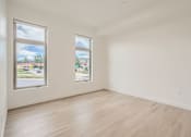Thumbnail 14 of 22 - a bedroom with hardwood floors and white walls