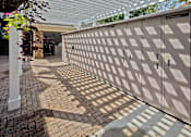 Thumbnail 22 of 25 - A large, beige, patterned gate blocks the view of a building.