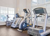 Thumbnail 22 of 30 - A gym with treadmills and elliptical machines.