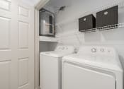 Thumbnail 15 of 35 - a white laundry room with a white washer and dryer and a white door