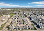 Thumbnail 21 of 40 - A suburban neighborhood with houses and a large open field.